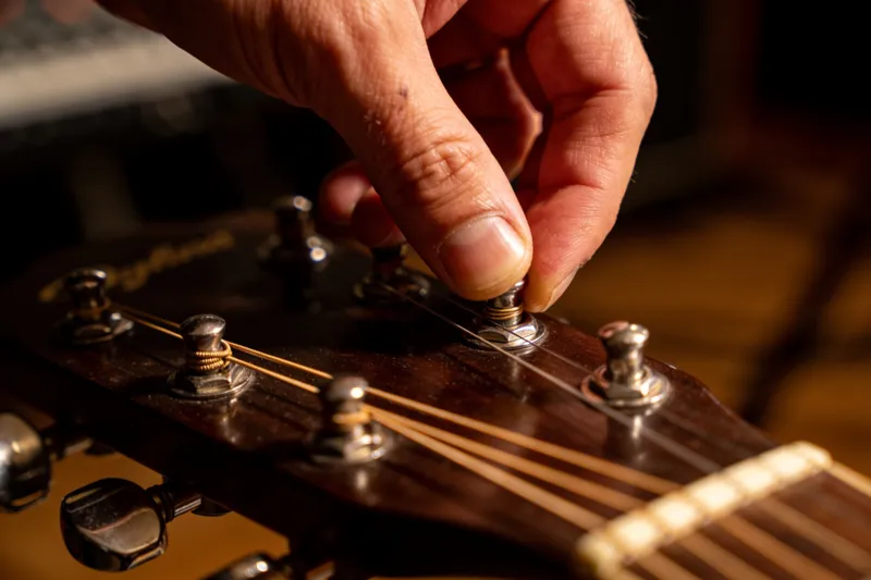 Een stemknop van de gitaar linksom draaien
